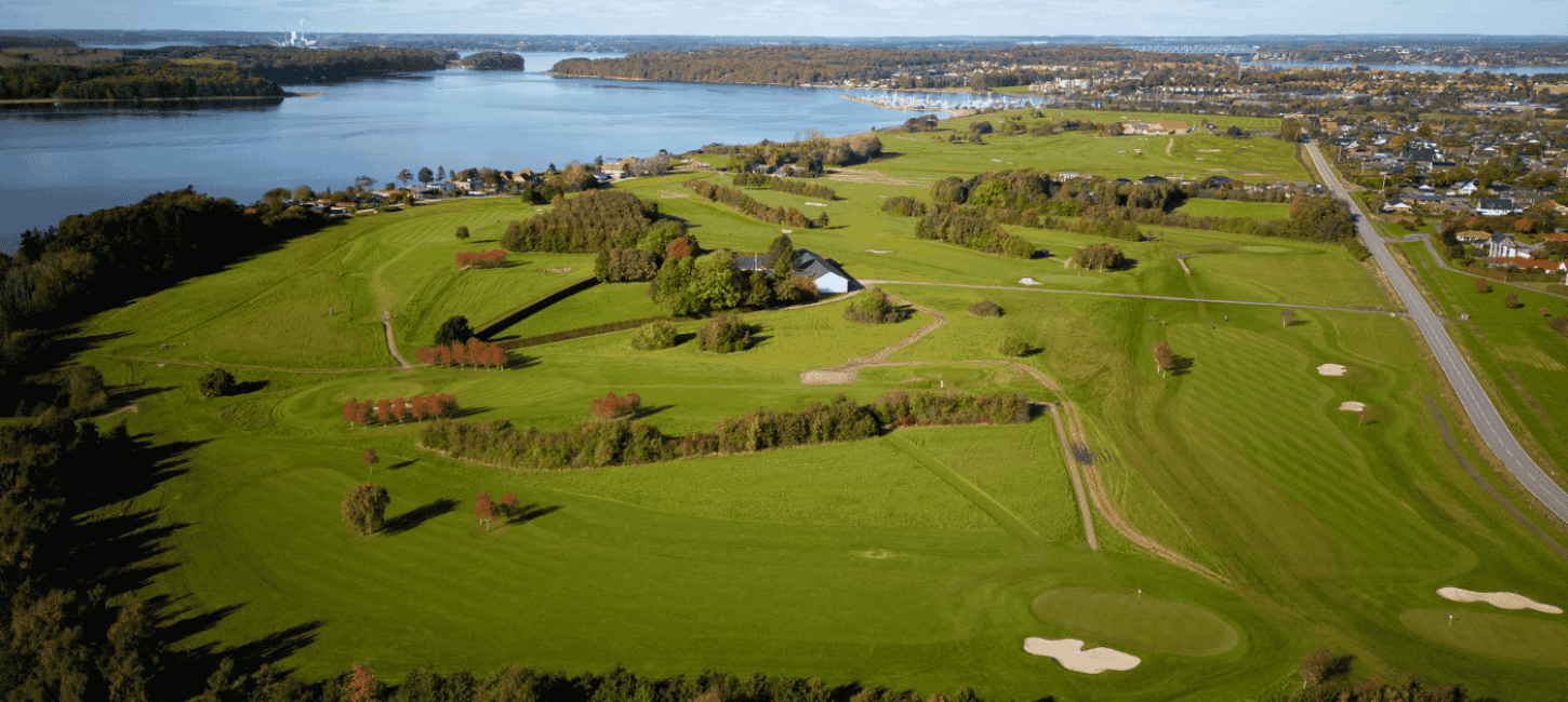 Luftfoto af golfbane tæt ved hav