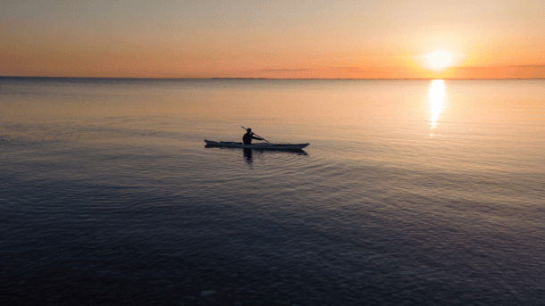 En havkajak på havet i solnedgang 